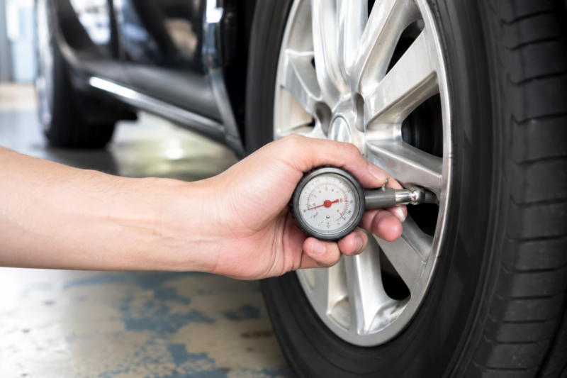 空気圧ゲージをタイヤのバルブに当てている手元カット
